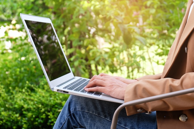 De toevallige bedrijfsvrouw werkt online op laptop die op toetsenbord hand