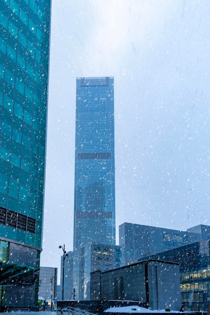 De toppen van moderne bedrijfsgebouwen in sneeuwval Lage hoekmening van wolkenkrabbers