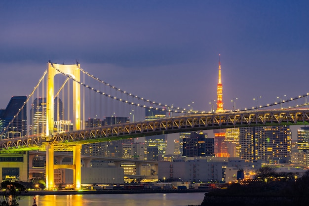 De toren van tokyo met de zonsondergang van de regenboogbrug