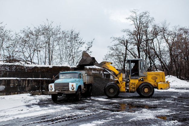 Foto de tractor laadt kolen in de vrachtwagen.