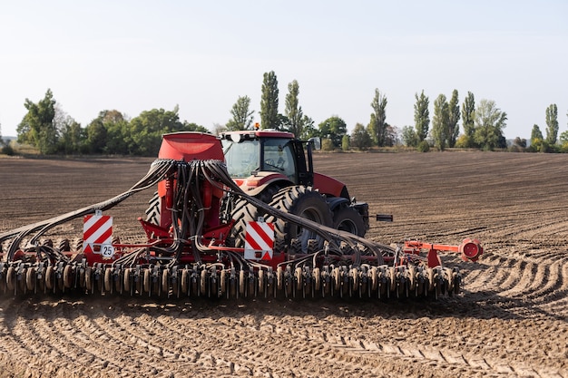 De tractor-oogstmachine aan het werk op het veld