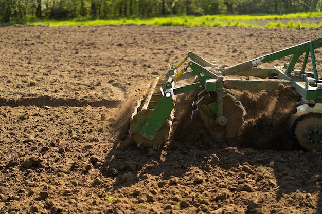 De tractor rijdt over het veld en bewerkte het land.