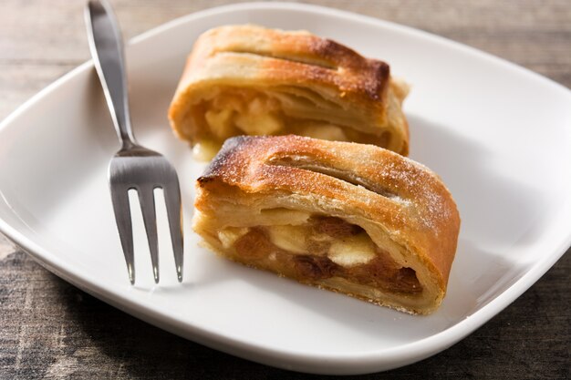 De traditionele eigengemaakte plak van de appelstrudel op houten lijst