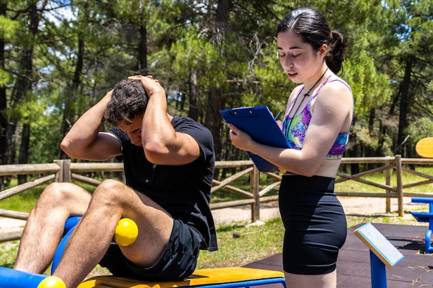 De trainer registreert de voortgang van de situp-oefening