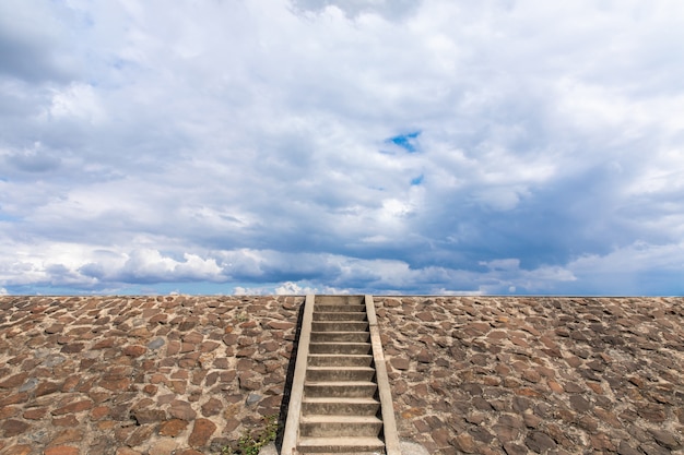 Foto de trap naar de dam is gevuld met stenen, bewolkte hemel