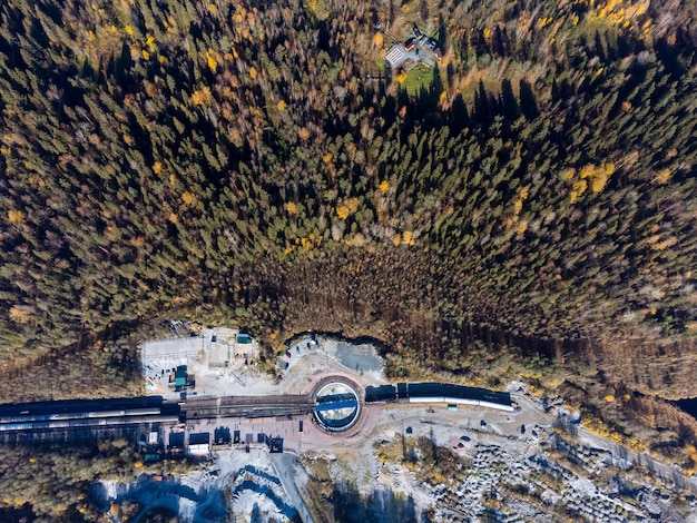 De trein is omgeven door een herfstbosmeerkloof en steengroeve van bovenaf Het Ruskeala Park uitzicht vanaf de drone