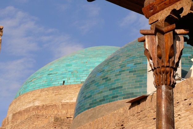 De turkooisblauwe koepels van Khiva met het onderschrift van een gebeeldhouwde pilaar