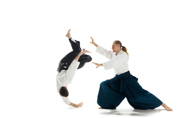 De twee mannen die vechten bij aikido trainen in een vechtsportschool