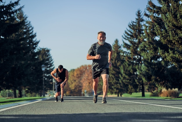 De twee sporters joggen op de weg