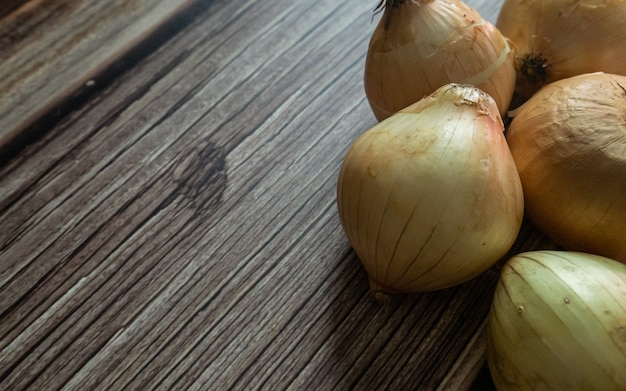 De uien op houten tafel voor eten of koken concept.