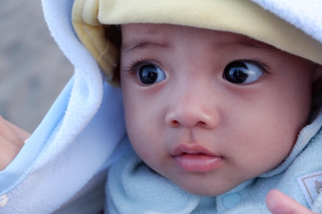 De uitdrukking van de baby wanneer hij door haar moeder wordt vastgehouden. Ze is een schattige baby.