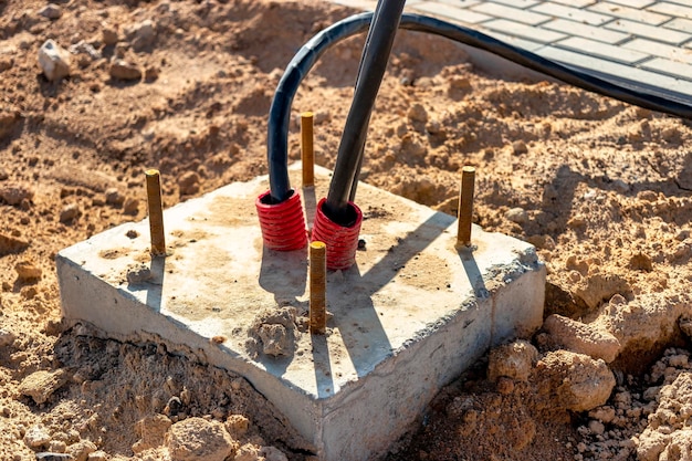 De uiteinden van de elektrische kabel in de greppel installatie van elektrische kabels Fundering voor verlichtingsstomp Elektrische bedrading voor stadsverlichting Bouwwerkzaamheden