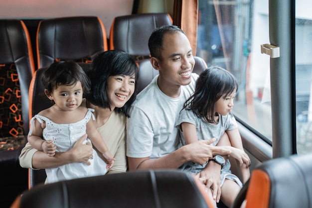 De vader en moeder hielden hun twee kinderen vast terwijl ze tijdens de reis op de busbank zaten