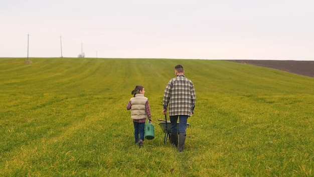 De vader en zoon lopen door het groene veld