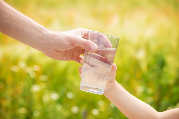 De vader geeft het kind een glas water. Selectieve aandacht.