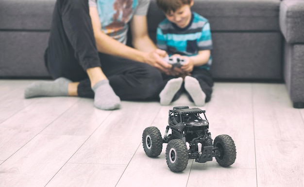 De vader leert zijn zoon rijden in de radiografisch bestuurbare auto