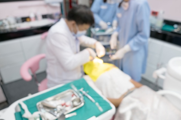 De vage beeldfoto van tandarts en zijn medewerker werken in kliniek.