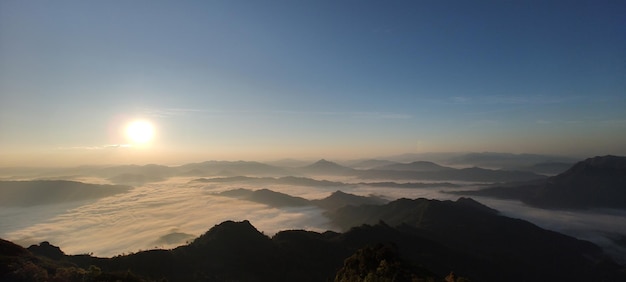 Foto de vallei en de bergkam worden bedekt door een zee van mist in de ochtend.