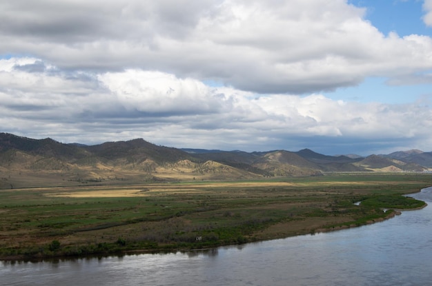 De vallei van de rivier onder een bewolkte bewolkte hemel Uitzicht op de rivier vanaf een hoogte