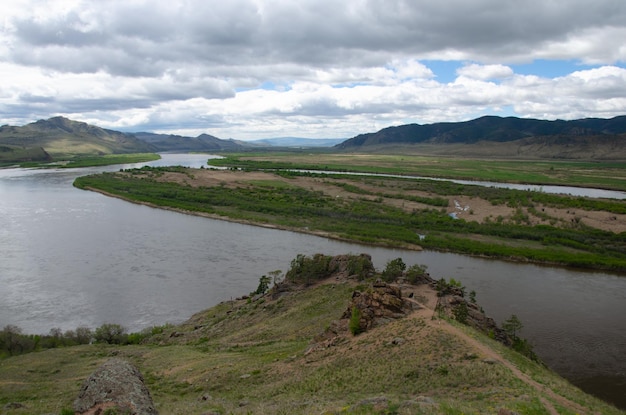 De vallei van de rivier onder een bewolkte bewolkte hemel Uitzicht op de rivier vanaf een hoogte