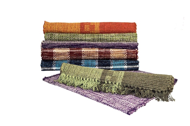 De veelkleurige Indiase katoenen tapijten voor het huis op een witte achtergrond close-up