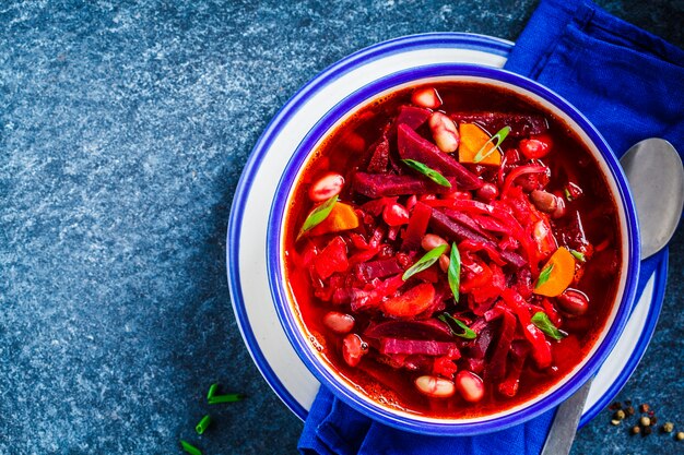 De vegetarische borsjt van de bietensoep met bonen in witte kom