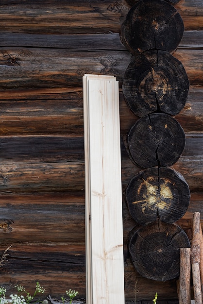 De verduisterde muur van een traditioneel houten huis Vers bord dat tegen een houten muur staat