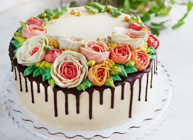 De verjaardagscake met bloemen nam op witte oppervlakte toe