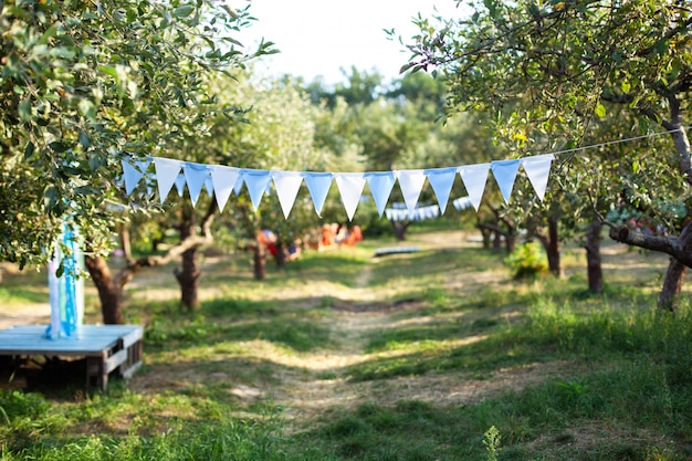 De verjaardagsdecoratie die van vlaggen op boomtak hangen in tuin. Tuinfeest decoratie. Bruiloft decor.