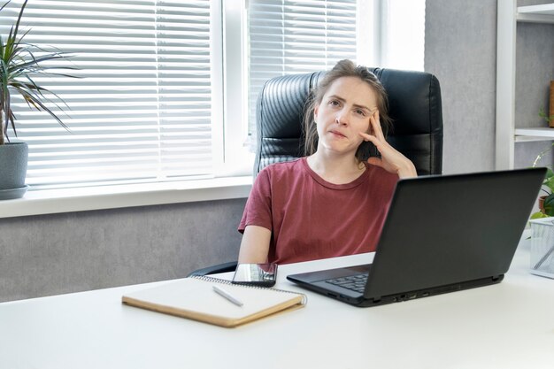 De vermoeide broeierige zakenvrouw op het werk denkt over het project na. professionele burn-out, beroepsmatige burn-out.