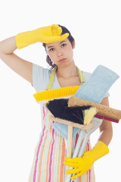 Foto de vermoeide vrouw die schoonmakende hulpmiddelen houdt