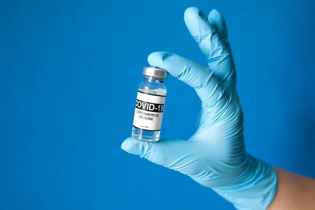 De verpleegster die het covid 19-vaccin in de hand houdt
