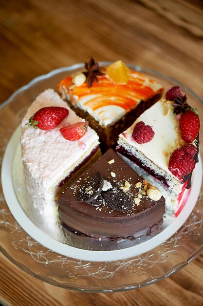 De verschillende stukken cake draaien soepel rond op de bodem Er is chocolade wortel yoghurt en bessen