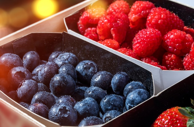 De verse bluberries, de frambozen en de aardbeien in een houten doos, sluiten omhoog