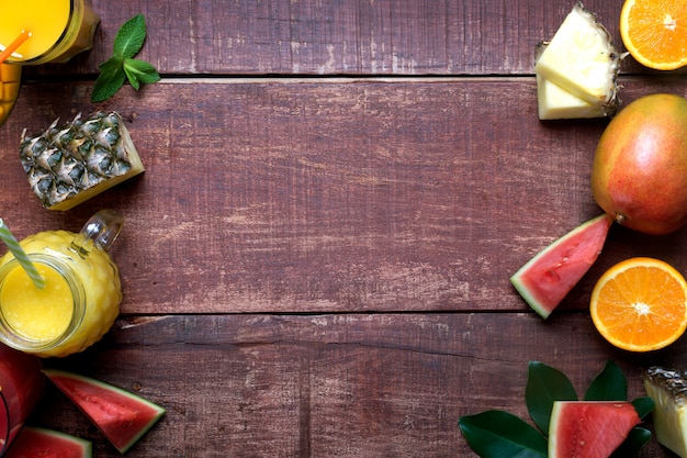 De verse multivruchten en een smoothie op een donkere houten rustieke vlakke achtergrond, leggen en kopiëren ruimte