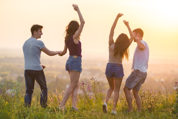 De vier actieve mensen dansen op het gras