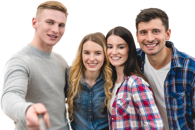 De vier vrienden maken een portret-selfie op de witte achtergrond