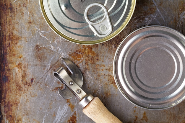 De vissen kunnen met blikopener op houten achtergrond