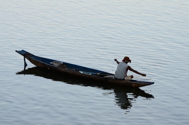 de visser zit op zijn boot in de rivier