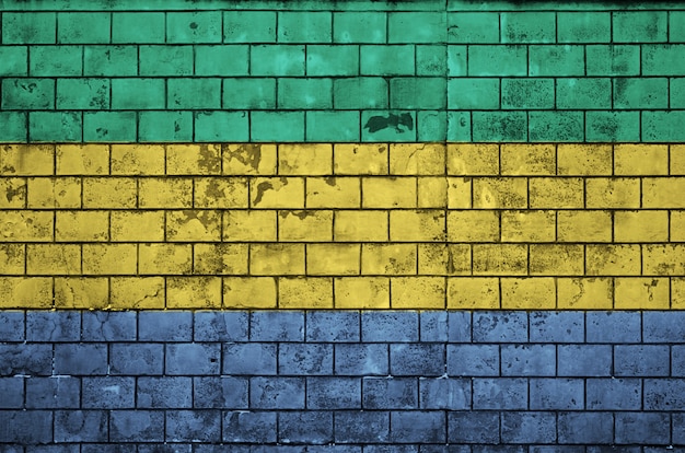 De vlag van Gabon is op een oude bakstenen muur geschilderd