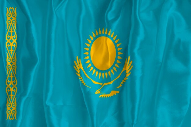 De vlag van Kazachstan op een zijden achtergrond is een groot nationaal symbool Textuur van stoffen Het officiële staatssymbool van het land