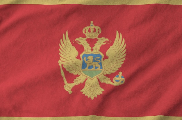 De vlag van Montenegro afgebeeld op gevouwen golvende stof van oude doek