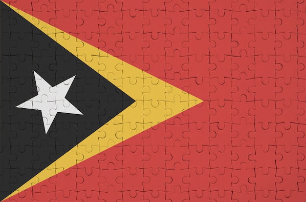 Foto de vlag van oost-timor is afgebeeld op een gevouwen puzzel
