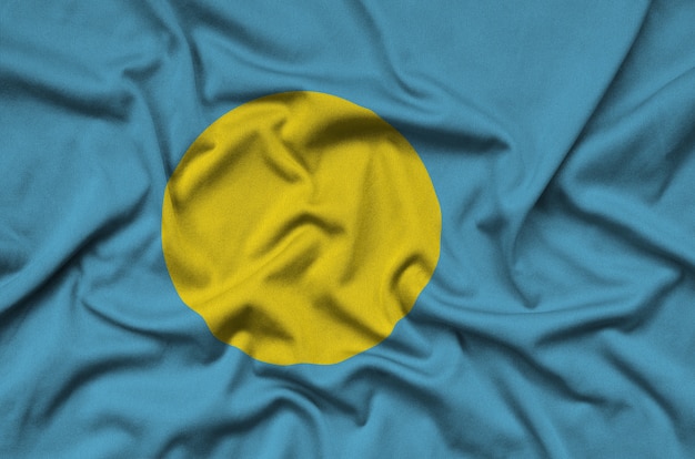 De vlag van Palau is afgebeeld op een sportdoek met veel plooien.