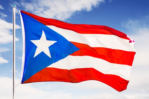 Foto de vlag van puerto rico zwaait onder de blauwe hemel.