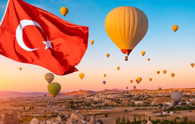 De vlag van Turkije tegen heteluchtballonnen in de lucht van Cappadocië, Turkije