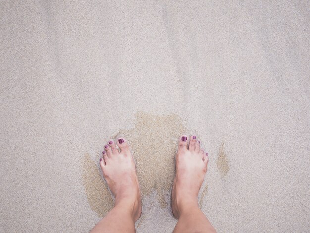 De voeten van de Selfievrouw op de achtergrond van het de zomerstrand.