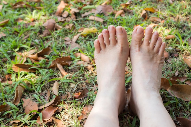 Foto de voeten van de vrouw op gras.