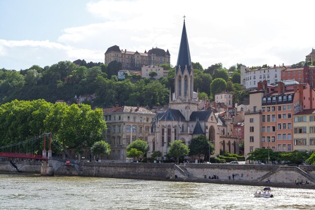 De voetgangersbrug van Saint Georges bij de kerk van Saint Georges wordt overhangt door de Saint Just High School in Lyon