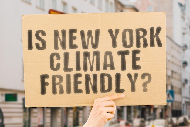 De vraag Is New york klimaatvriendelijk staat op een spandoek in mannenhanden met onscherpe achtergrond Support Team Activist Urban Sunset Carbon Ecology Energy New Clean Warming Waste